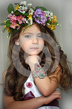 Beautiful little girl wearing a wreath of flowers