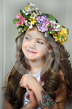 Beautiful little girl wearing a wreath of flowers