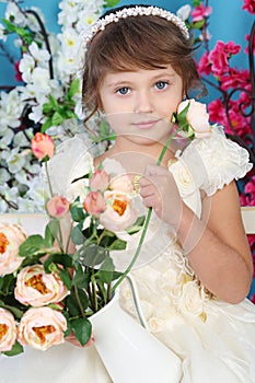 Beautiful little girl in white dress sits on bench