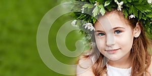 Beautiful  little girl in a white dress  in spring wood. Portrait of the pretty little girl with a wreath from spring flowers on