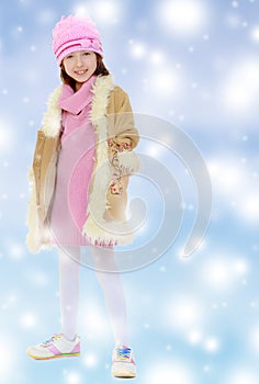Beautiful little girl in winter coat with fur.