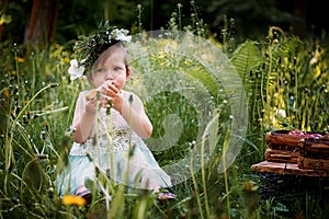 Beautiful little girl in a wreath on the head in green and white. Dress, Princess. With pleasure, but the nature