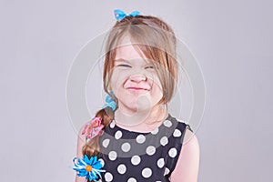 A beautiful little girl writhing a funny face