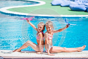 Beautiful little girls having fun near an outdoor pool