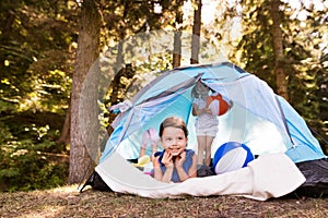 Beautiful little girls in tent camping by the lake.