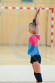 Beautiful little gymnast training on the carpet and ready for competitions