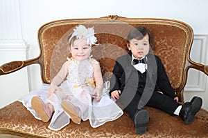 Beautiful little kids in costumes bride and groom photo