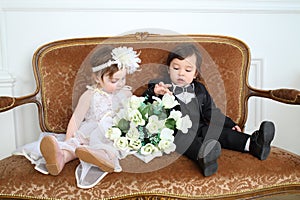 Beautiful little kids in costumes bride and groom photo