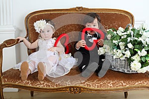 Beautiful little kids in costumes bride and groom photo