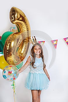 Beautiful little princess in blue dress. Birthday party for cute child.