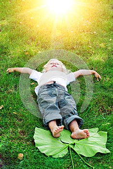 Beautiful little toddler girl happy lying on grass