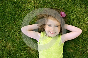 Beautiful little toddler girl happy lying on grass