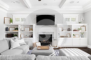 A beautiful living room with built-in shelves around a fireplace and mounted television.