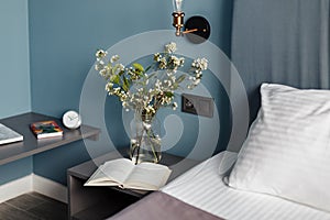 Beautiful living room with flowers and a book on the bedside table