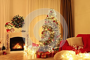 Beautiful living room interior with burning fireplace and Christmas tree in evening