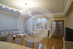 Beautiful living room interior with hardwood floors and fireplace roaring fire in new luxury home.