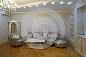 Beautiful living room interior with hardwood floors and fireplace roaring fire in new luxury home.