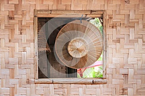 local handmade Asian hat on surface of bamboo hanging on the window of a bamboo house