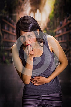 Beautiful and lonely girl suffering of anorexy, holding her stomach and putting his fingers in her mouth to induce to