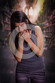 Beautiful and lonely girl suffering of anorexy, putting his fingers in her mouth to induce to vomit, in a blurred