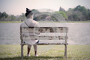Beautiful lonely woman in frustrated depression sitting alone on photo