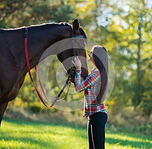 Beautiful long hair young woman with a horse outdoor