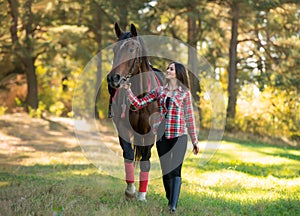 Beautiful long hair young woman with a horse outdoor