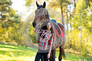 Beautiful long hair young woman with a horse outdoor