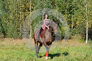 Beautiful long hair young woman riding a horse