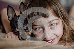 Beautiful long-haired little girl with a dog Chihuahua