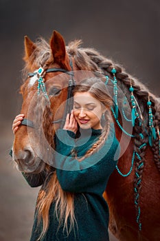 Beautiful long-haired  young woman  with red tinker horse in christmas decor