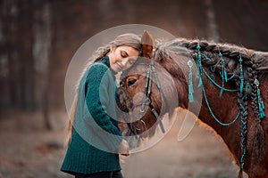 Beautiful long-haired  young woman  with red tinker horse in christmas decor