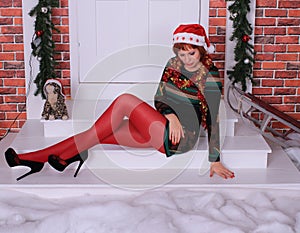 Beautiful long legged redhead girl in red stockings and heels  posing in Christmas decoration