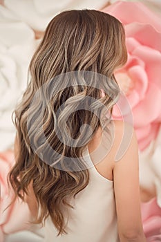 Beautiful long wavy hair style. Bride wedding hairstyle over flowers copyspace. Beauty hairdressing salon