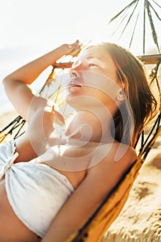 Beautiful longhaired young woman losting in dream rest in hammock. Sunny portrait