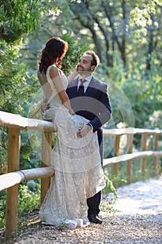 Stylish bride and groom at a park on their wedding day. Beautiful love story in nature, couple in love