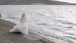 Beautiful and lovely bride near sea. Pretty and well-groomed woman. Close up shot. Blonde. Wedding day
