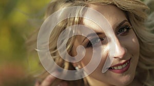 Beautiful and lovely bride in the park. Pretty and well-groomed woman. Close up shot. Blonde. Wedding day