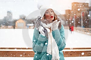 Beautiful lovely middle-aged girl with curly hair warm winter jackets stands ice rink background Town Square