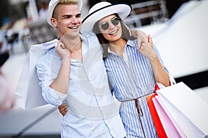 Beautiful loving couple carrying shopping bags and enjoying together.