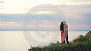 Beautiful loving couple on the edge of the cliff dancing and hugging