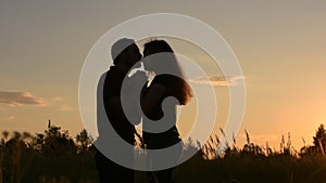 Beautiful loving couple holding hands looking at each other. At sunset.