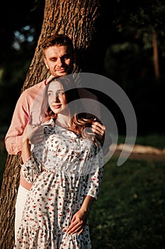 Beautiful loving couple are hugging outdoors in the park. romantic woman and stylish man are having fun outdoors. happy summer