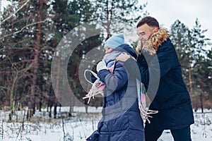 Beautiful loving couple running in winter forest together. People having fun outdoors