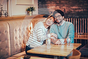 Beautiful loving couple sitting in a cafe drinking coffee and conversating