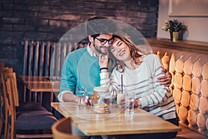 Beautiful loving couple sitting in a cafe drinking coffee and conversating