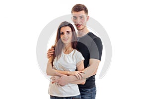 Beautiful loving couple stand in front of the camera holding each other and smiling