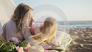 Beautiful loving family with blonde mother and little girl bonding ocean beach