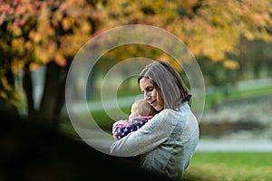 Beautiful loving moment with young mother hugging her baby gir