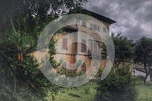 Beautiful low angle shot of an old house in the middle of a field under the gloomy sky